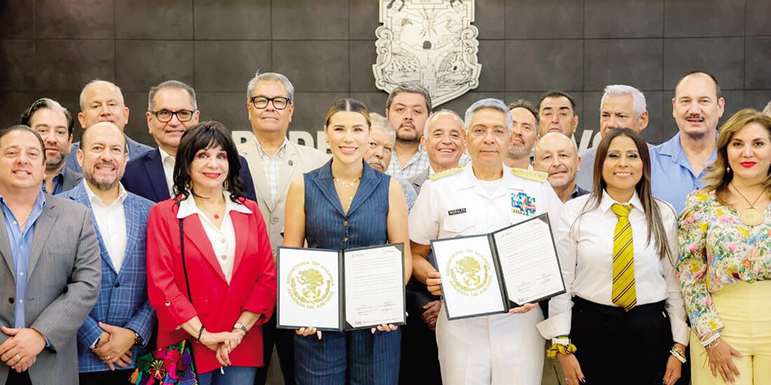 Marina del Pilar Ávila (4.a de izq. a der.), y Raymundo Pedro Morales, con funcionarios, ayer, en la firma del convenio.