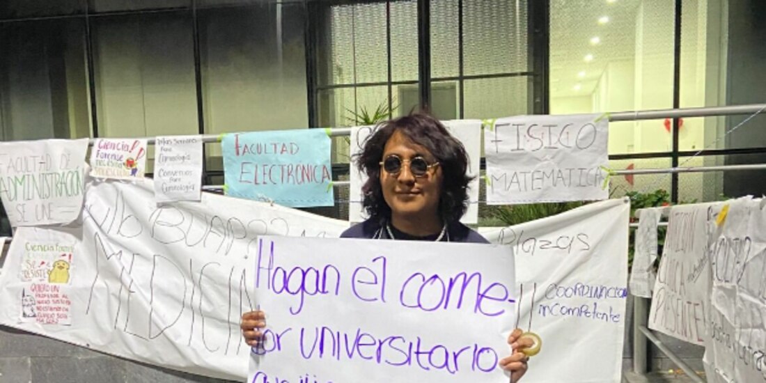Un estudiante inconforme exhibe una cartulina con una demanda específica afuera de una de las instalaciones que permanecen tomadas, ayer.