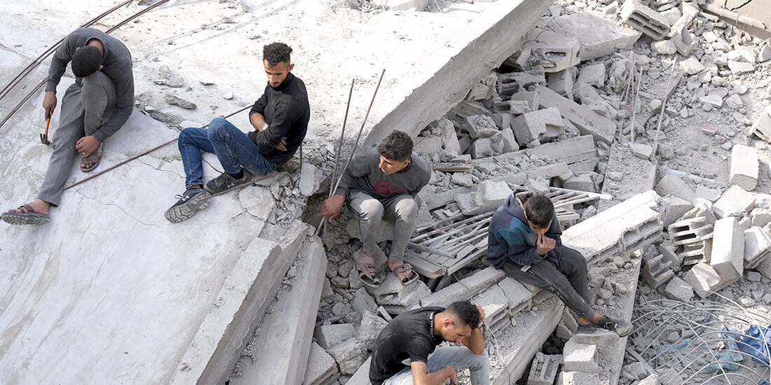 Palestinos se lamentan sobre las ruinas de una casa, en Gaza, ayer.