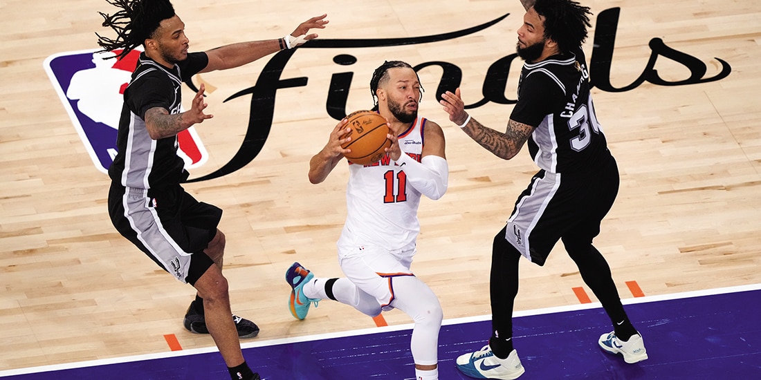 Jalen Brunson intenta pasar entre dos jugadores de los Spurs, el lunes pasado.