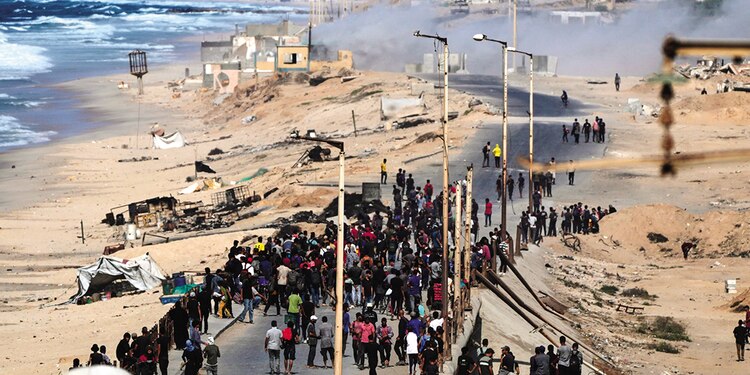 Palestinos desplazados se reúnen en la carretera costera cerca de Wadi Gaza tras el anuncio de que Israel y Hamas habían acordado la primera fase de un plan de paz, ayer.