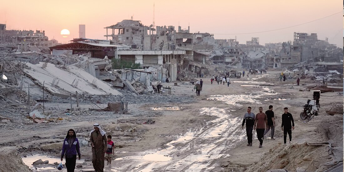 Palestinos caminan entre edificios destruidos en Khan Yunis, al sur de la Franja de Gaza, ayer.