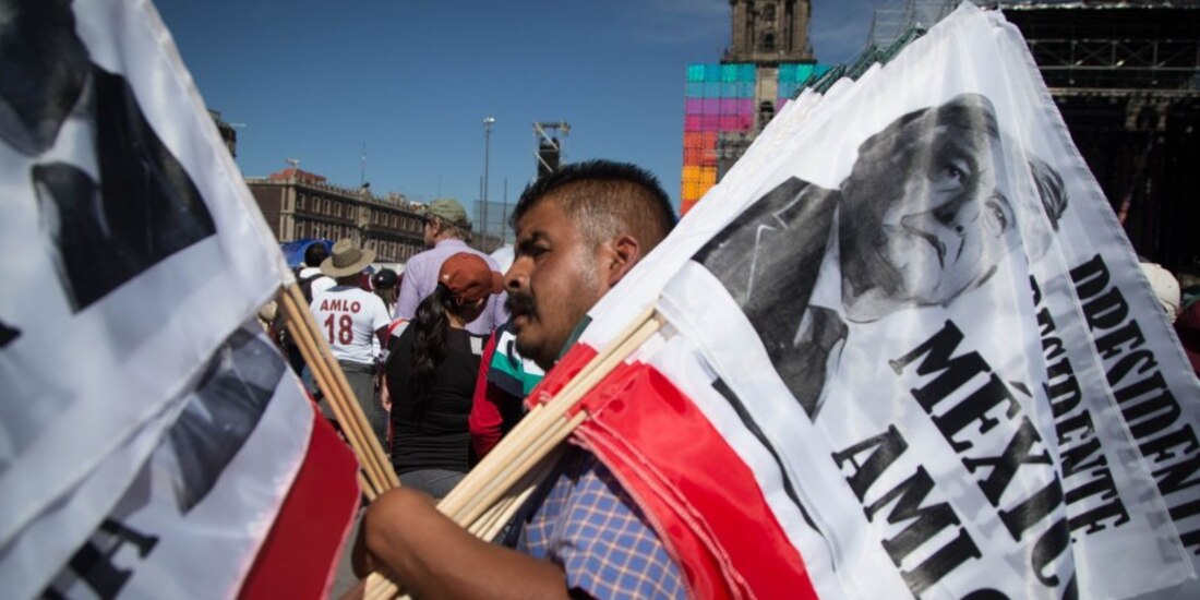 Sujeto carga banderas con la imagen de López Obrador