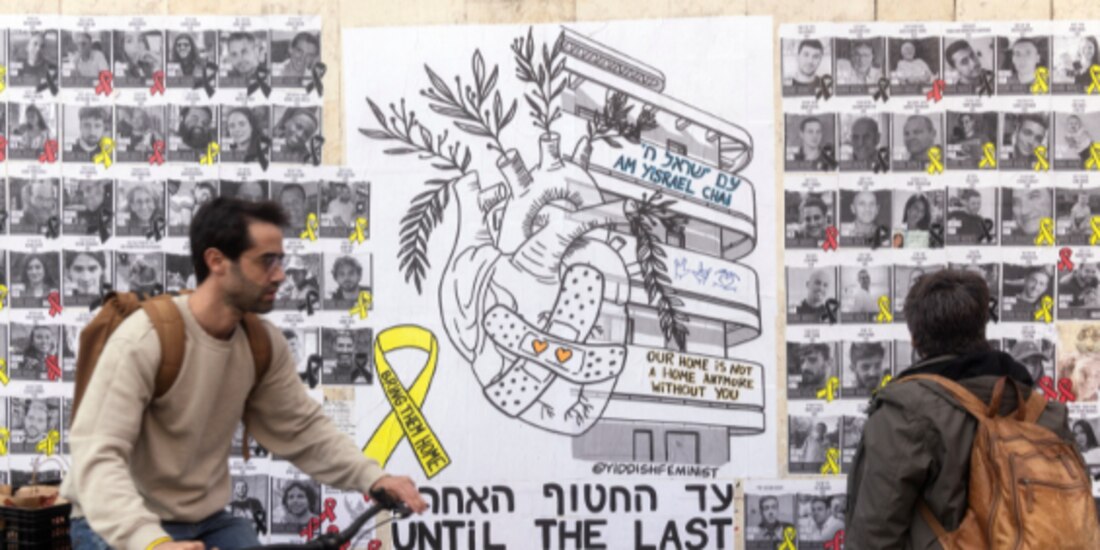 Una residente observa un mural con los rostros de víctimas de Hamas, ayer.