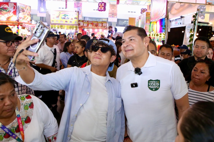 Gobernador Alejandro Armenta posa para una fotografía con un asistente de la Feria de Puebla.