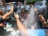 Manifestantes chocan con agentes que los rocían con gas, ayer.
