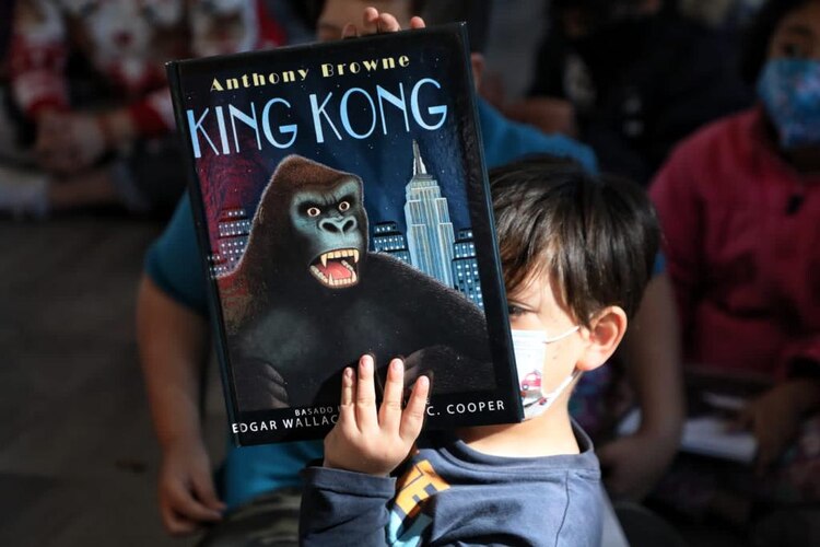 Niño muestra un libro que le regalaron.