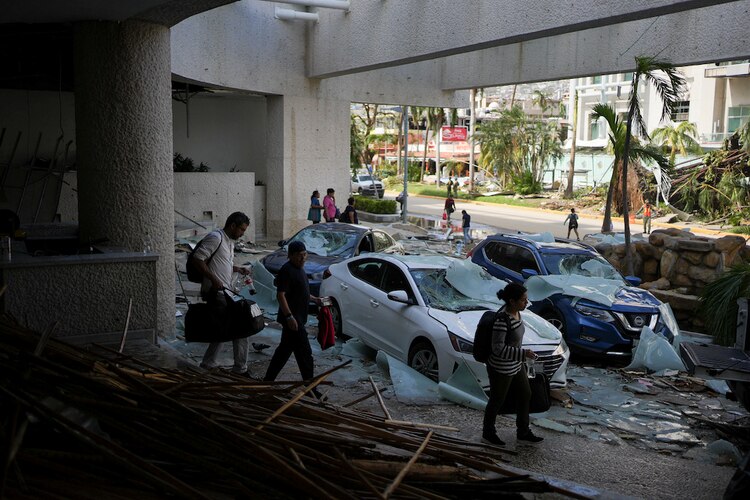 Turistas abandonan uno de los hoteles afectados por el meteoro.