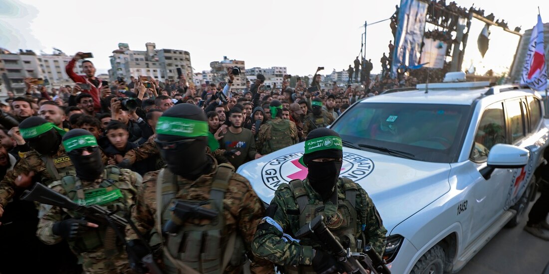 Combatientes de Hamas escoltan vehículo que recogió a rehenes liberadas, ayer.