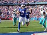 Josh Allen (17), quarterback de los Buffalo Bills, corre rumbo a la zona de anotación para un touchdown en frente del safety de los Miami Dolphins, Jevon Holland, en el juego de Semana 4 de la NFL