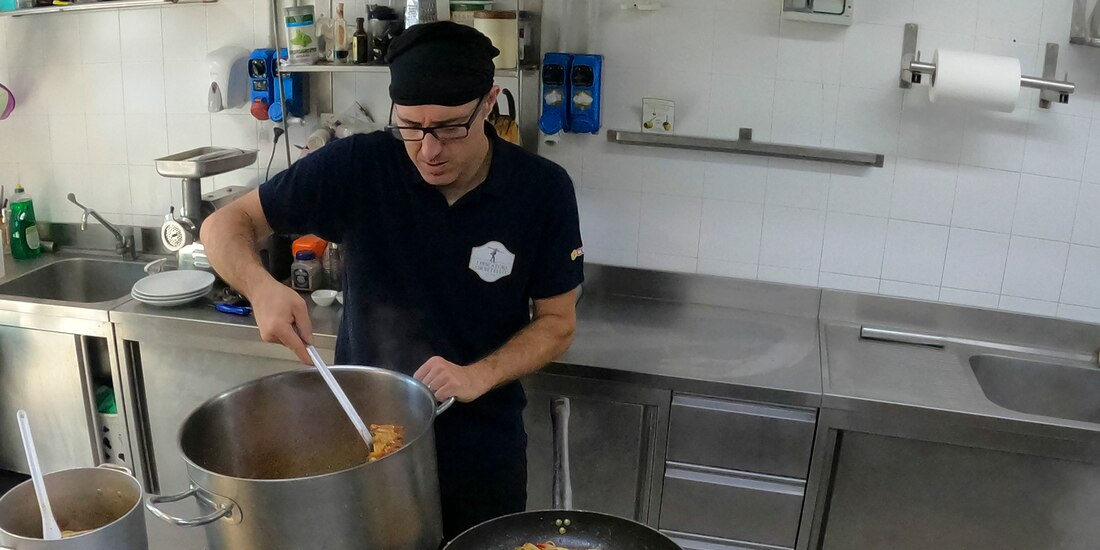 Un cocinero prepara pasta con cangrejo azul en un restaurante de Orbetello, Italia, el lunes 14 de agosto de 2023.