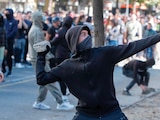 UN JOVEN lanza una piedra durante una protesta antigubernamental en Tirana, ayer.