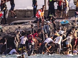 ARRIBO de inmigrantes a enclave español por mar y tierra, ayer.