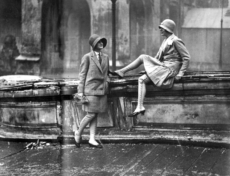 Imagen de dos mujeres sentadas en la calle.