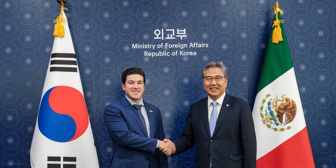 Ambos funcionarios en saludo fraternal.