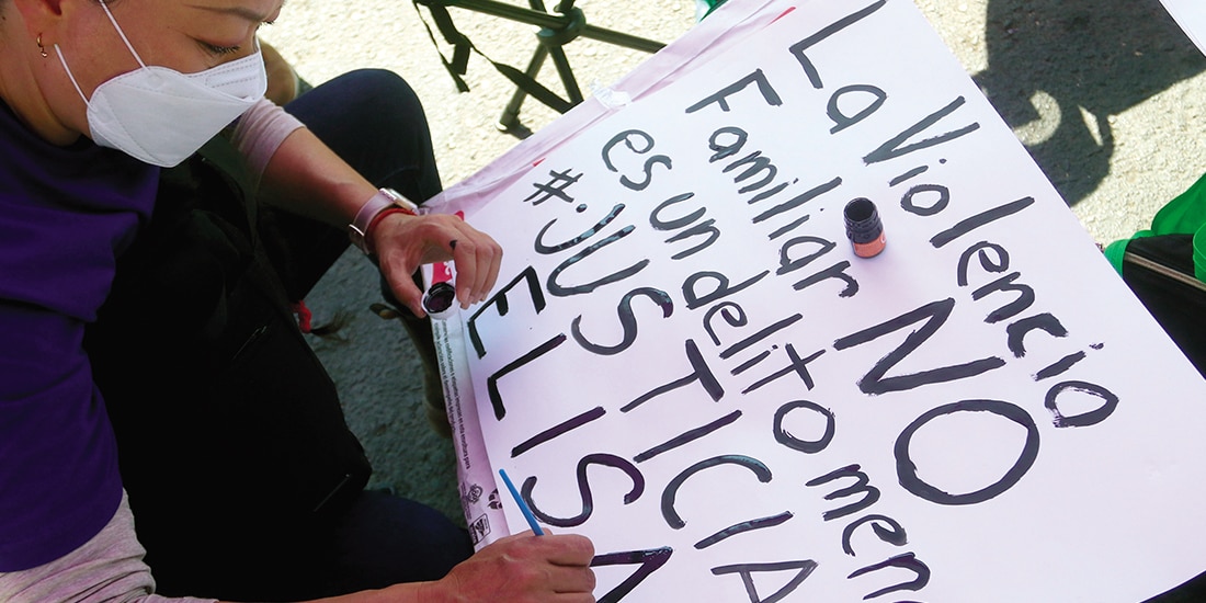 UNA MUJER pinta una cartulina para protestar, en imagen de archivo.
