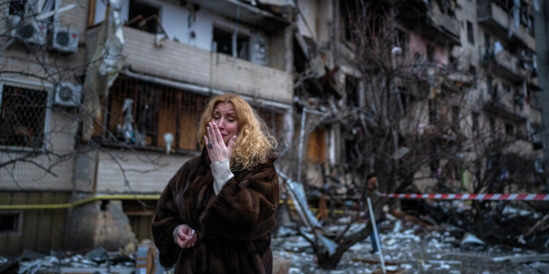 Una mujer llora frente a los escombros que dejó un ataque ruso en Kiev, Ucrania.