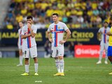 Pedri y Robert Lewandowski, jugadores del Barcelona, durante la pausa en el partido ante el Cádiz mientras atendían a un aficionado en las gradas.