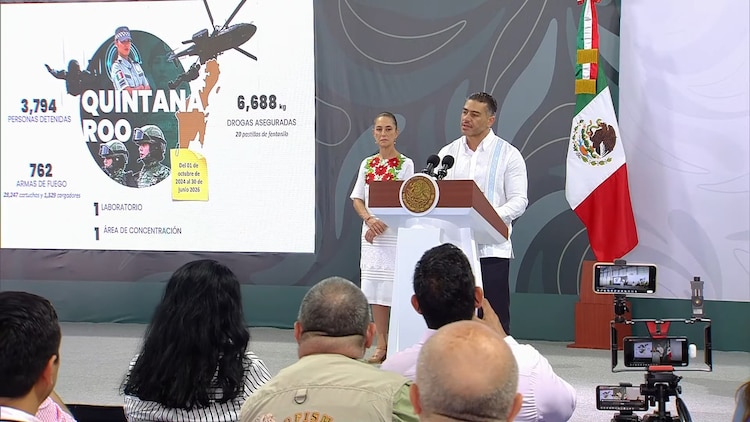 Omar García Harfuch, titular de la SSPC, en la Conferencia; detrás, la presidenta Claudia Sheinbaum.