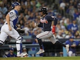 Ozzie Albies, de los Braves, corre hacia el home y pasa al receptor de los Dodgers, Will Smith, para anotar en la quinta entrada.