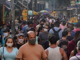 Transeúntes, la mayoría con mascarillas debido al coronavirus, recorren un mercado callejero en el centro de Río de Janeiro, Brasil, el jueves 25 de junio de 2020. (AP Foto/Leo Correa)