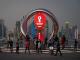 Gente reunida alrededor del reloj de la cuenta regresiva oficial que muestra el tiempo restante para el inicio del Mundial Qatar 2022.
