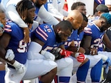 Jugadores de los Bills de Buffalo se arrodillan durante el himno.