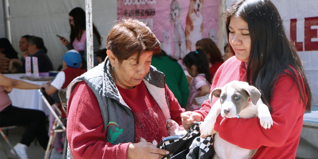 UN PAR de mujeres carga a su mascota durante el Peluditos Fest de San Antonio Tecómitl, el 28 de julio de 2025.