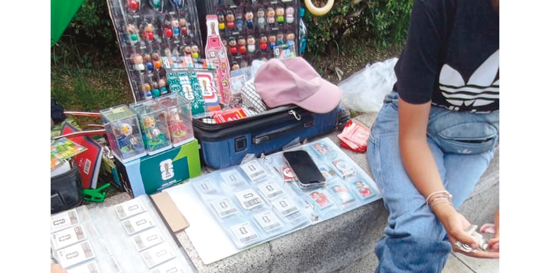 UNA JOVEN da cambio a un hombre que le compró diversas estampas, ayer.