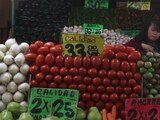 En la imagen, una mujer comerciante acomoda sus legumbres y verduras para venderlas. El Inegi reportó que