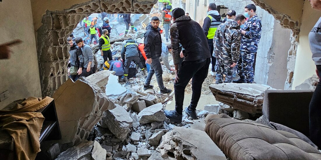 A través de un hueco en un edificio golpeado por armas israelíes se observa a socorristas y civiles tras el impacto, ayer, en Líbano.