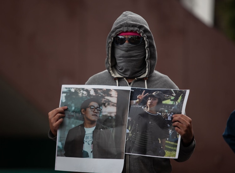 Un manifestante con retratos de Miguel y Berenice, fotoperiodistas muertos en AXE Ceremonia.