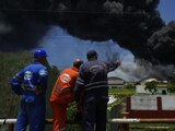 Trabajadores de CUPET observan una columna de humo que se eleva desde la Base de Superpetroleros de Matanzas, Cuba.