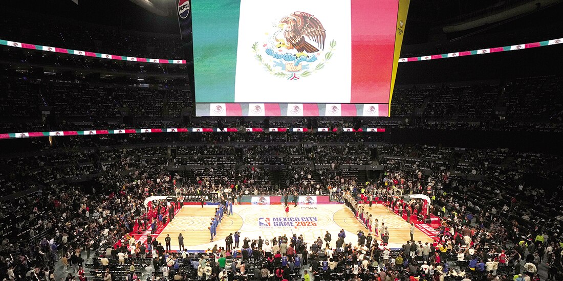 Jugadores de Pistons y Mavericks escuchan el Himno Nacional de México, el sábado.