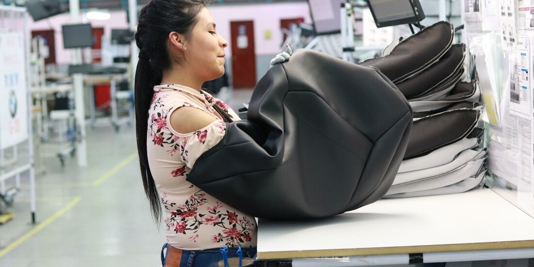 Una mujer trabaja en una planta manufacturera del sector automotriz