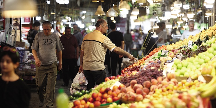 Un hombre compra en un mercado local en Teherán, en medio de las sanciones de EU, ayer.