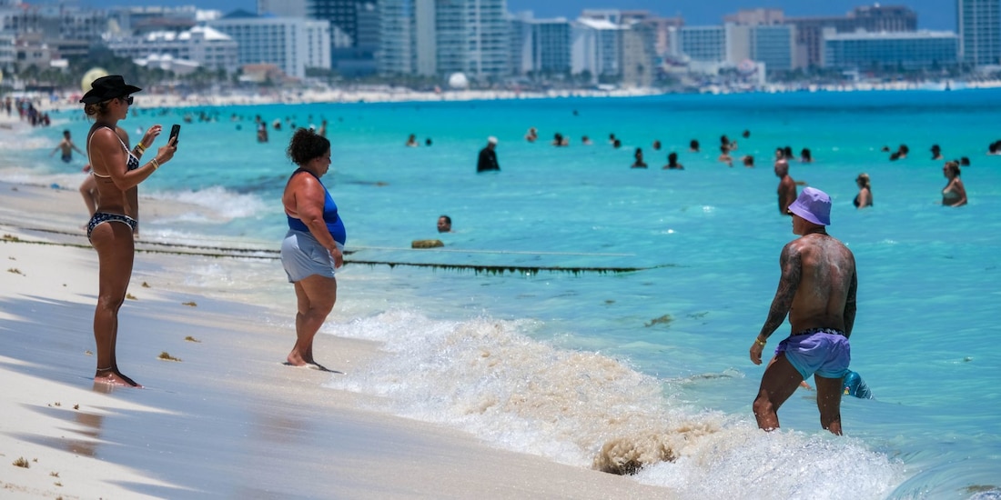 Turistas extranjeros y nacionales disfrutando de un día soleado en la playa