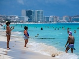 Turistas extranjeros y nacionales disfrutando de un día soleado en la playa