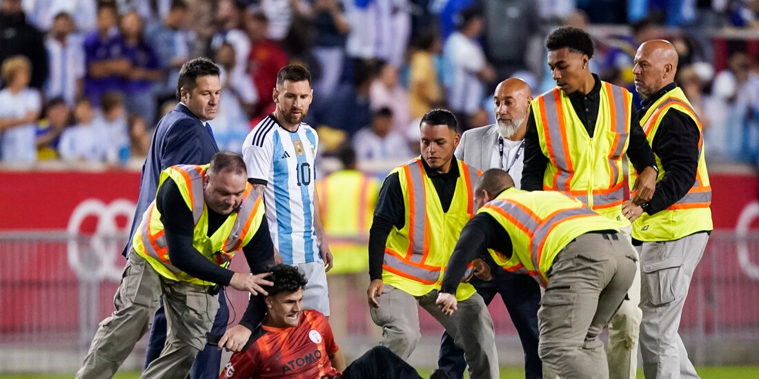 Lionel Messi observa al aficionado que fue derribado por la policía al final del partido amistoso entre Argentina y Jamaica.