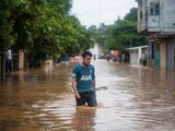 Un joven camina en una calle inundada en Acayucan, Veracruz.