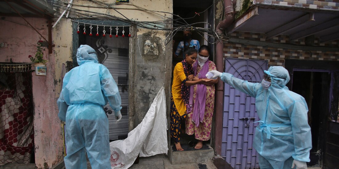 Un trabajador de la salud le da desinfectante de manos a una niña durante un campamento de control en un barrio pobre en Mumbai, India, el 17 de junio de 2020.