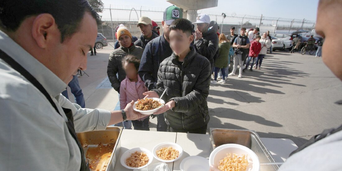 Extranjeros reciben comida tras la cancelación de citas CBP, en Tijuana, ayer.