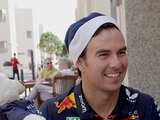 Checo Pérez sonríe al abrir el regalo que recibió con motivo de la Navidad.