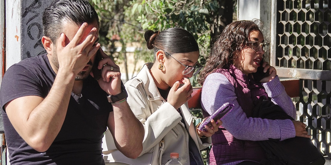 Un hombre y dos mujeres hablan por teléfono en la Ciudad de México, el pasado 12 de enero.