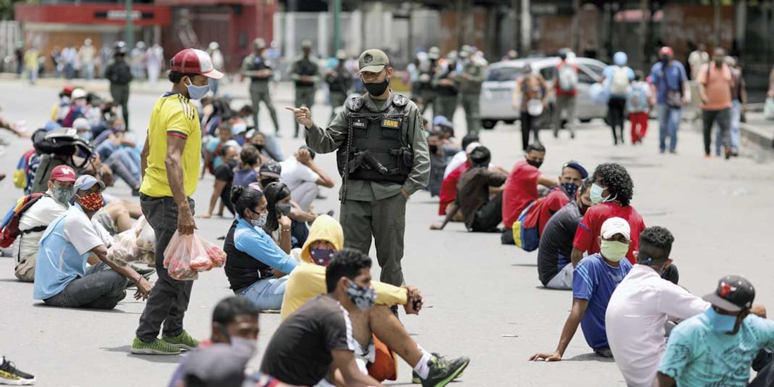 Miembros de la Guardia Nacional vigilan a personas que incumplen normas de salud.