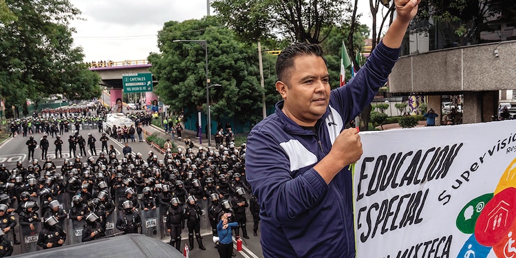 Contingente de uniformados, detrás de un integrante de la CNTE.