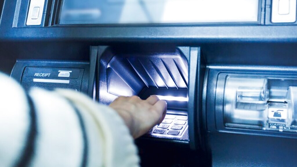 Una persona tecleando su nip en un cajero.