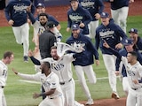 Beisbolistas de los Rays celebran el triunfo de ayer que los deja seguir .