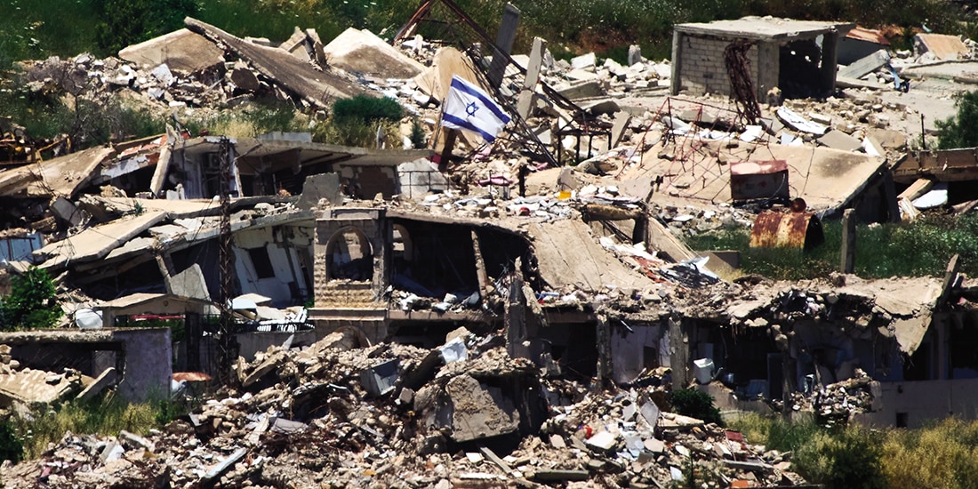 Una bandera israelí ondea en un edificio destruido en el sur del Líbano, vista desde el norte del país, ayer.