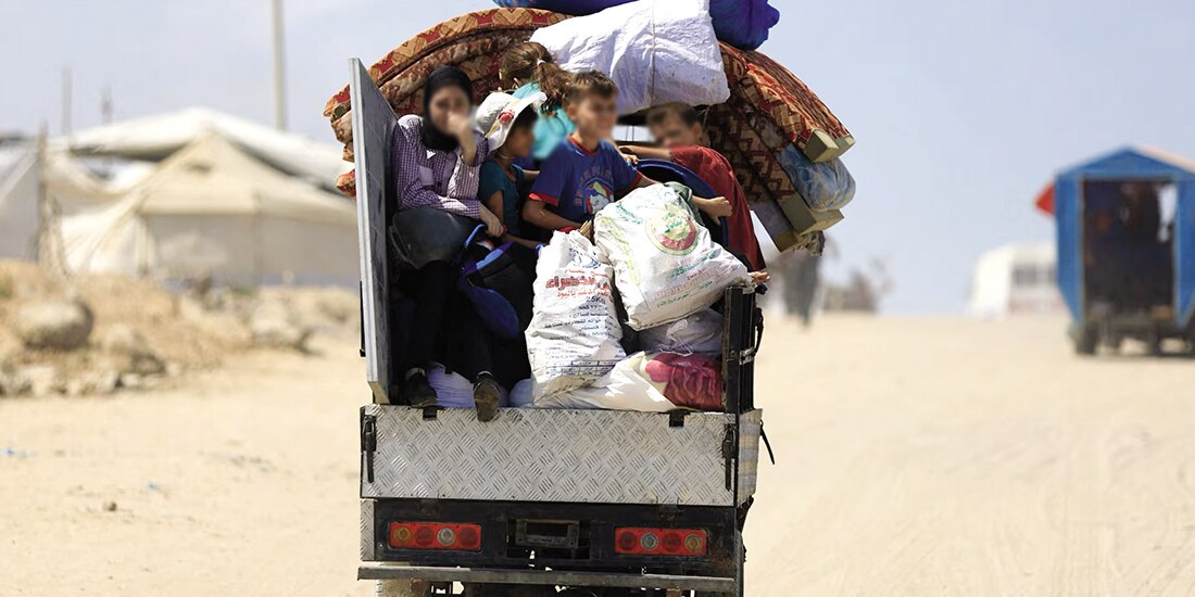 Mujeres palestinas desplazadas que huyen del norte de Gaza viajan con sus pertenencias, para dirigirse hacia el sur, ayer.